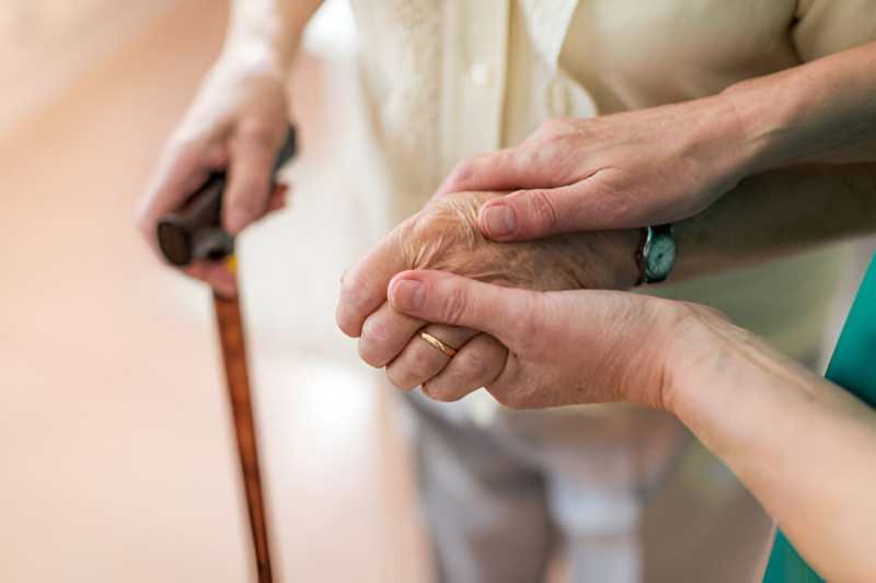 consoling-her-elderly-patient-by-holding-her-hands