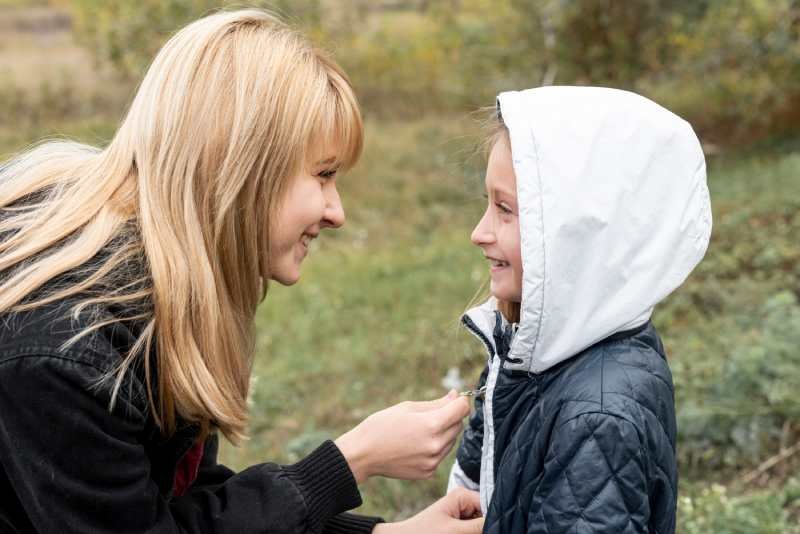 woman-arranging-daughter-jacket