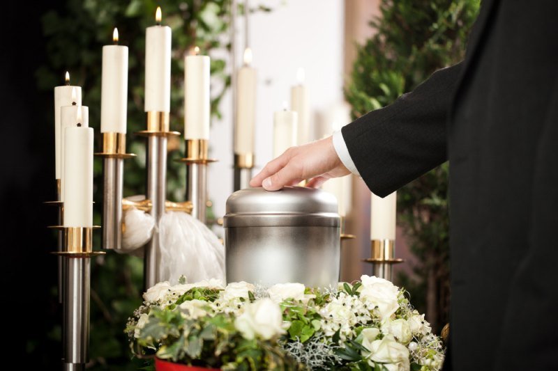 Funeral urn with candles and flowers