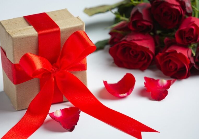 Red roses and gift box on marble background