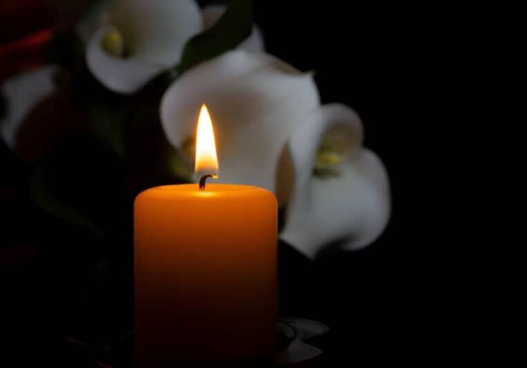 orange candle flame and lily flowers